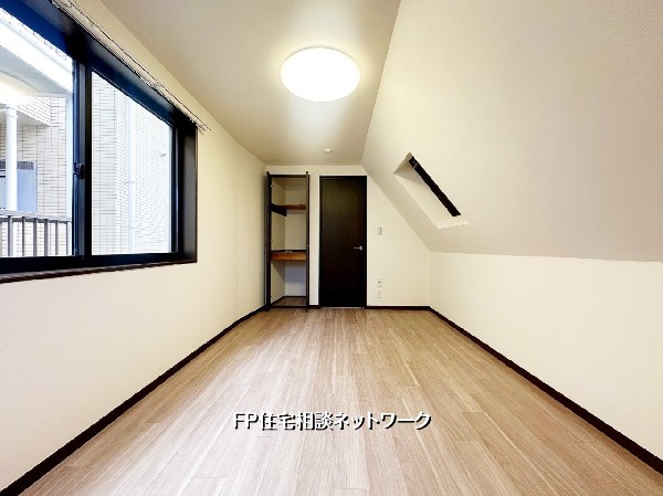 勾配天井が生む奥行きある空間設計。窓からの採光で明るさを確保しつつ、収納も備えた使い勝手の良い一室。寝室や趣味部屋にも最適です。