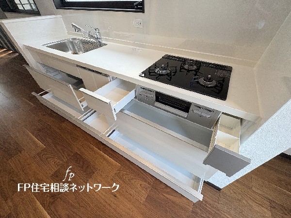 スライド収納付きのシステムキッチン。料理器具なども収納できて出し入れもスムーズ。収納量もたっぷりなので料理器具やストック調味料なども入れられる。