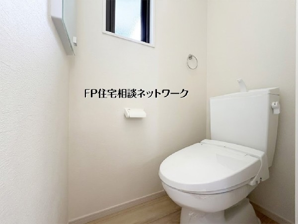 【トイレ】  白を基調とした清潔感のあるトイレ空間です。小窓から差し込む自然光が明るさを演出し、圧迫感を軽減。便利なタオル掛けやペーパーホルダーも完備され、日々の暮らしを快適にサポートします。