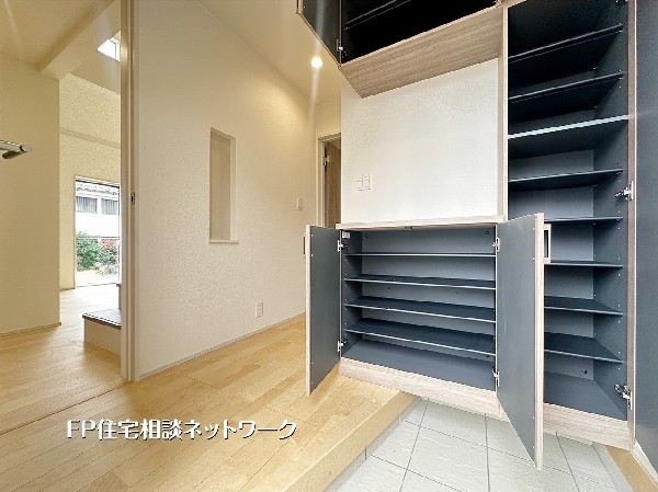 【玄関│シューズボックス】収納力豊富なシューズボックスを備えた玄関。可動棚で靴の高さに合わせて調整でき、家族分もしっかり収まるすっきりとした空間です。