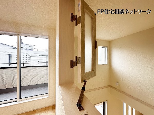 【洋室│7.9帖】2階洋室から階下のLDKへとつながる、遊び心あふれる室内小窓。家族の気配をさりげなく感じられる設計で、家全体に一体感と開放感をもたらします。