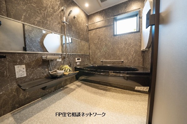 【プラン例　建物価格2480万円　建物面積100m2】重厚感のある壁面デザインで統一した浴室。落ち着いた色調でまとめ、毎日のバスタイムをゆっくり楽しめる空間です。