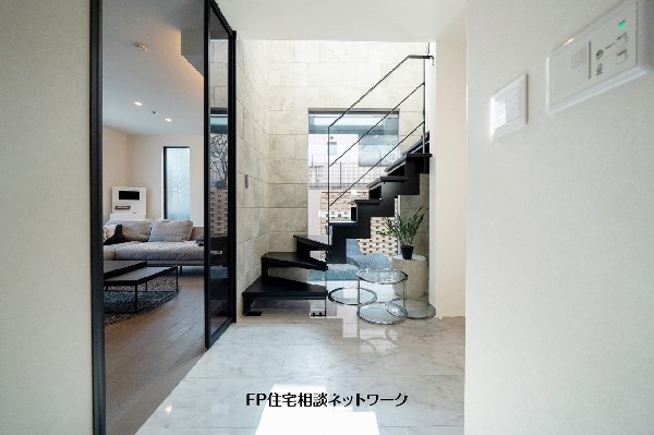 【プラン例　建物価格2480万円　建物面積100m2】吹抜けと鉄骨階段が開放感を演出する玄関ホール。室内にいながら中庭とのつながりも感じられる設計です。