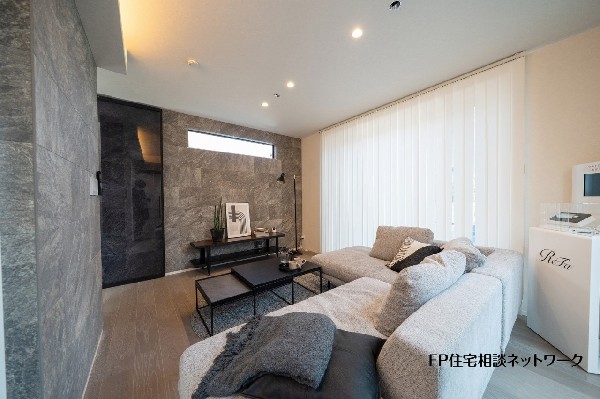【プラン例　建物価格2480万円　建物面積100m2】石目調のアクセントウォールが印象的なリビング。落ち着いた色合いでまとめ、ゆったりくつろげる空間に仕上げました。