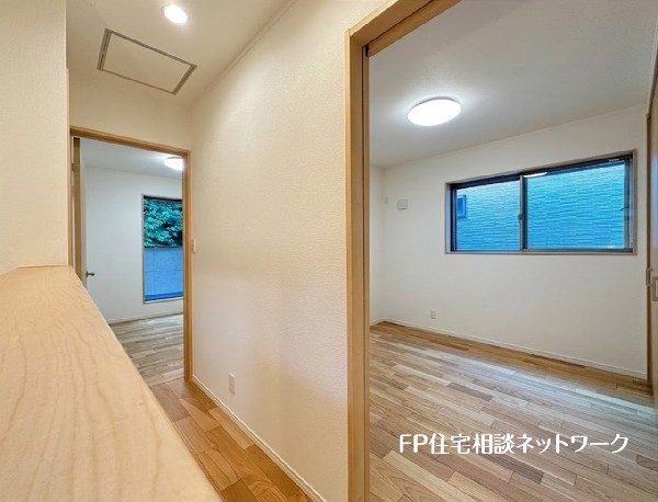 【2階廊下】  木の温もりを感じる明るいフローリングが魅力的な室内です。各部屋に窓があり、自然光がたっぷり差し込む心地よい空間。飾り棚として使える便利なカウンターも備え、快適な新生活を彩ります。