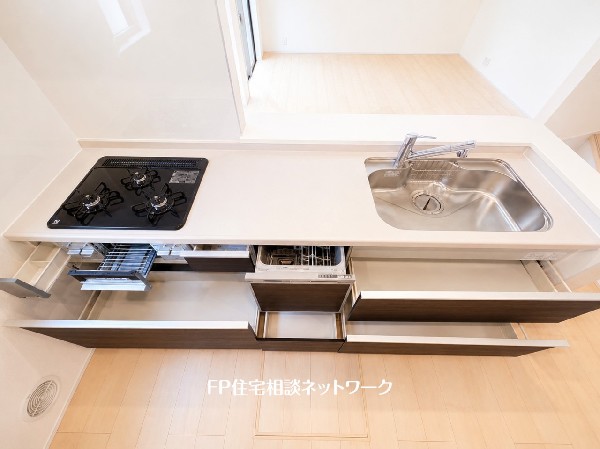 スライド収納付きのシステムキッチン。料理器具なども収納できて出し入れもスムーズ。収納量もたっぷりなので料理器具やストック調味料なども入れられる。