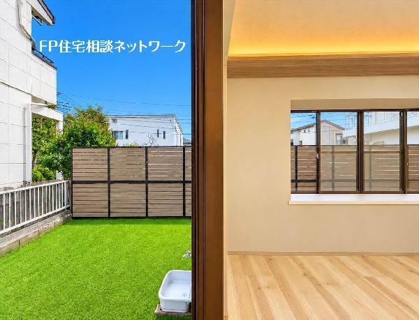 外観:【庭│リビング】  窓越しに庭の緑を楽しめる、明るいリビング。木目の床と間接照明のやわらかな光が、家族で過ごす時間を心地よく彩ります。