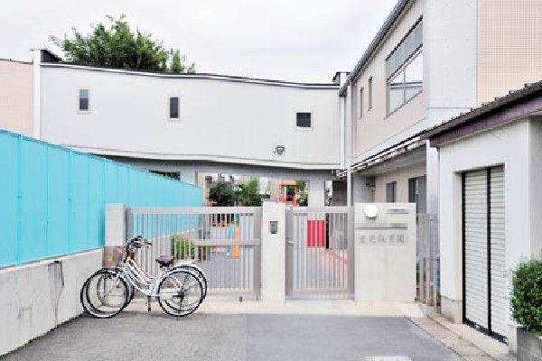 周辺環境:愛光保育園(駅から続く道の途中に広い緑の空間を提供する園庭では、定員150名の園児が自由遊びに興じている。木とコンクリートでできたきれいな園舎は、数年前に改築されたものです。)